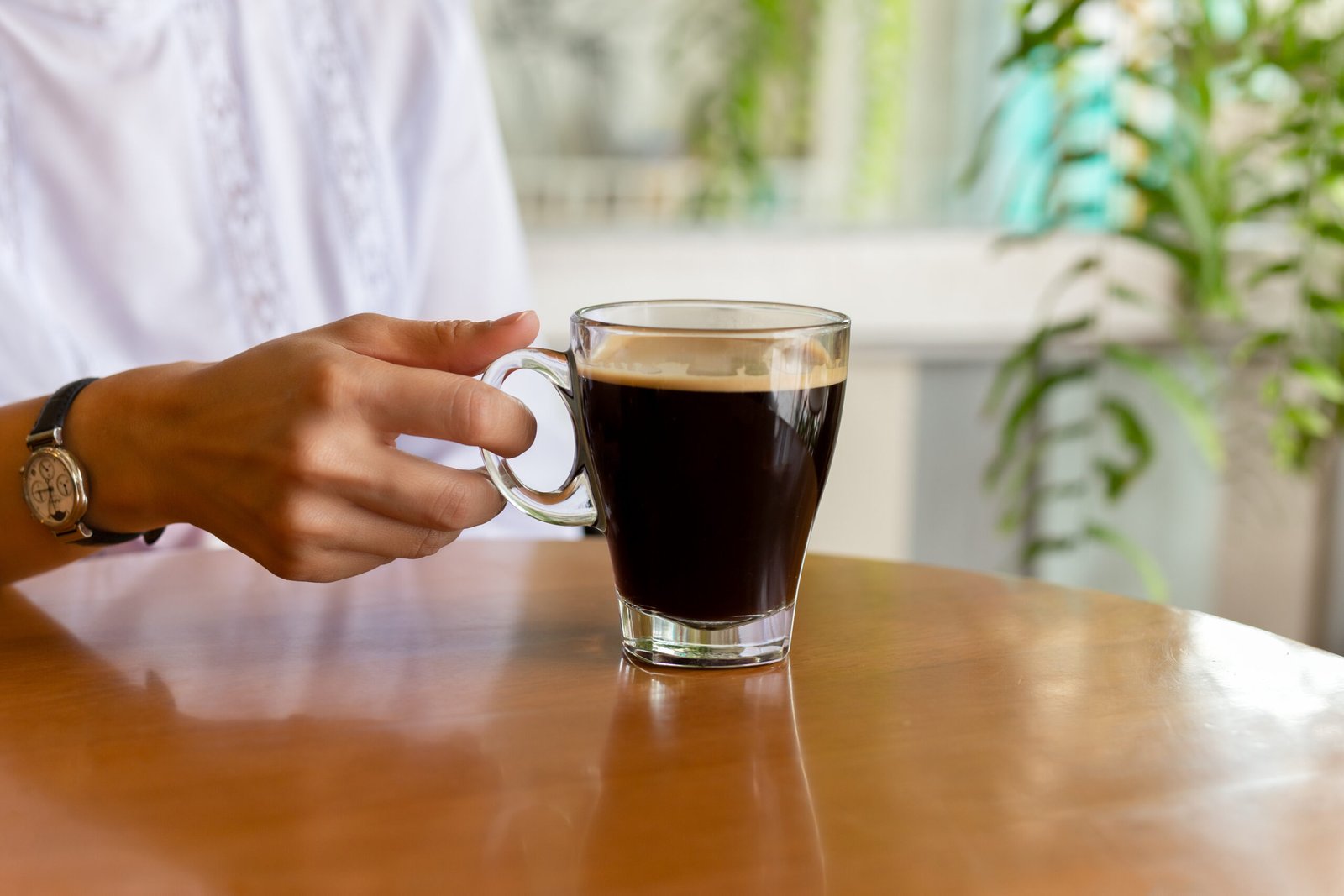 woman holding mug of black coffee