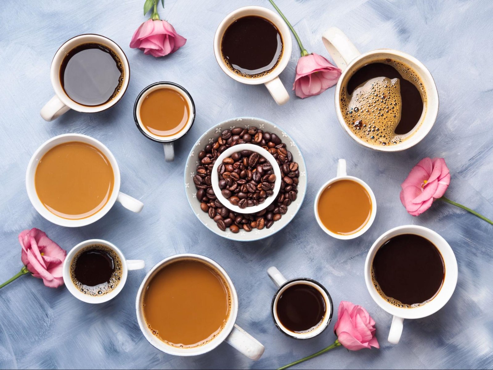 Cups of coffee, beans and pink flowers