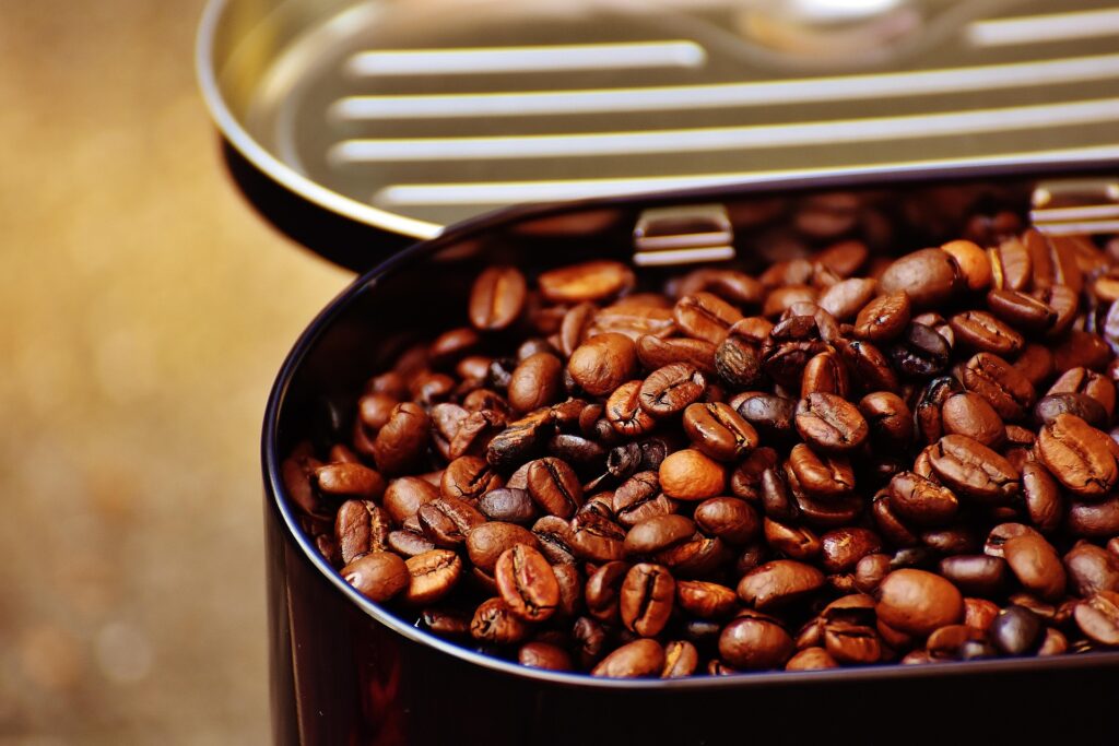 Close-up of roasted beans in a container, showcasing water-processed decaf coffee with rich color and texture