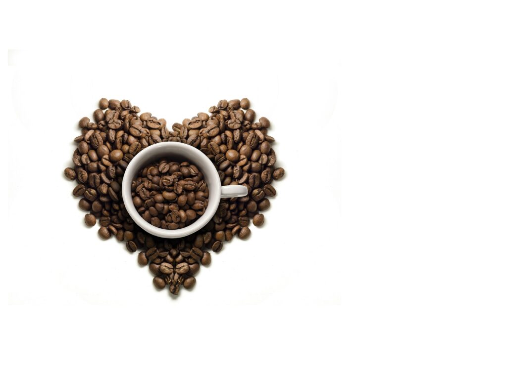Cup of coffee surrounded by beans arranged in heart shape, representing specialty coffee brands and their focus on quality and connection